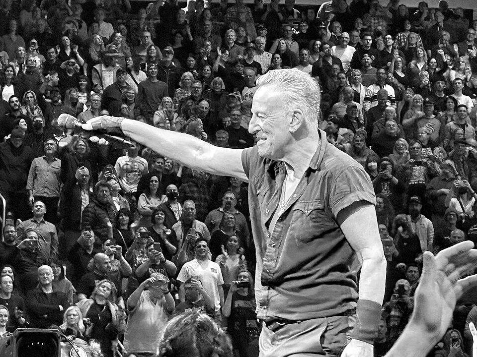 Bruce Springsteen reaching toward the crowd in concert, Seattle, 2023